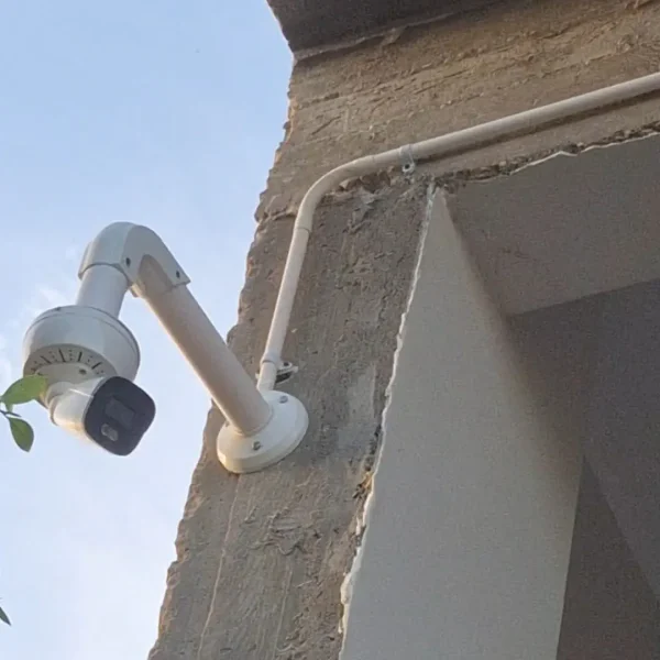 تركيب كاميرا مراقبة خارجية على حامل جداري بارز مع حماية الكابلات بمواسير بيضاء